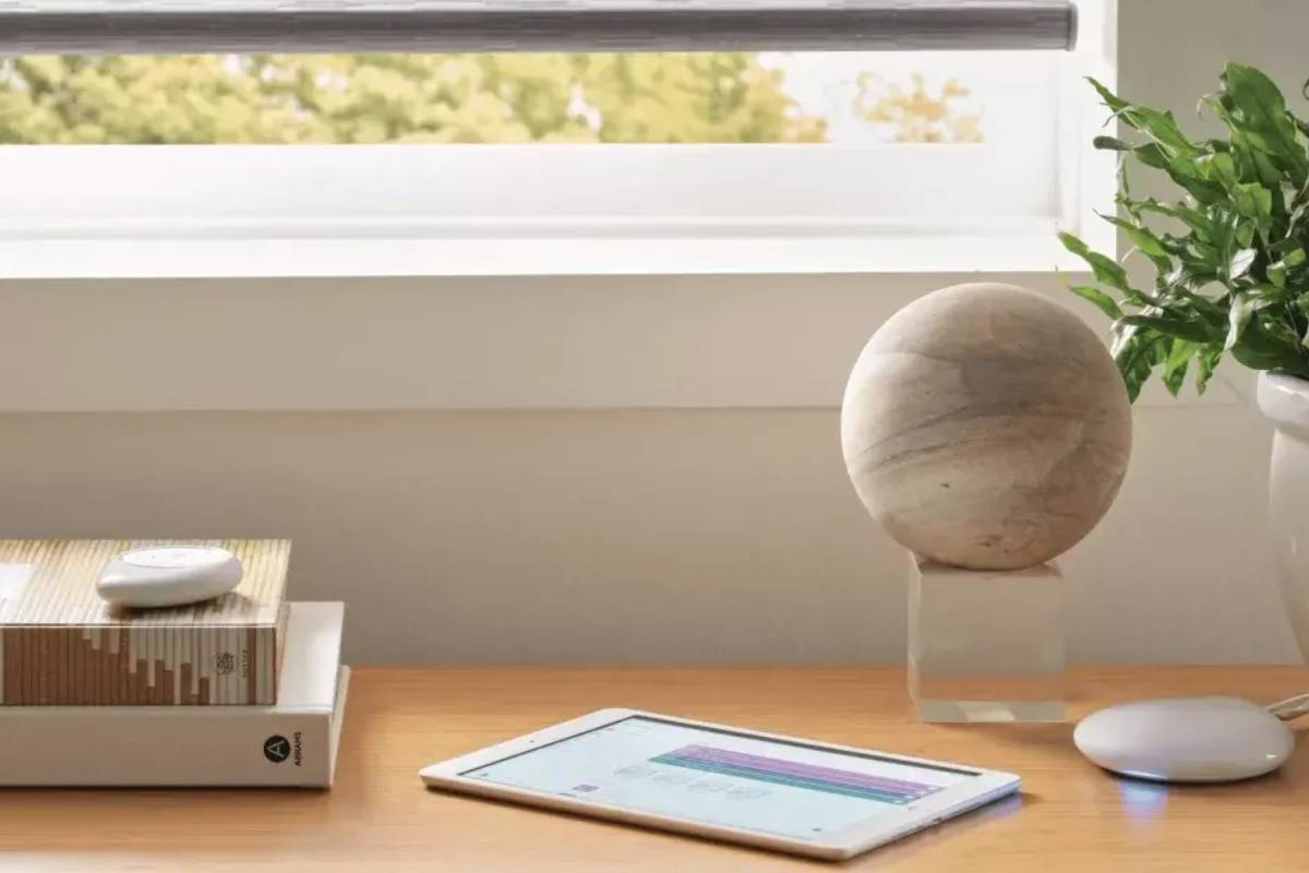 A tablet open to the Hunter Douglas PowerView® App next to the PowerView® Hub on a table