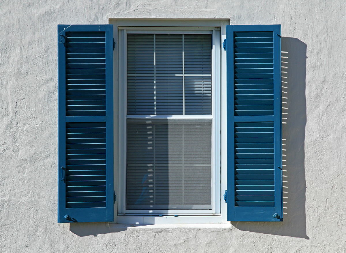 A set of blue window shutters on the exterior of a home