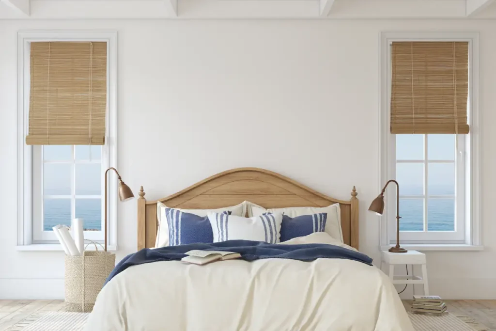 Types of Window Shades for Charleston and Beaufort Homes 1 Minimal coastal bedroom with woven shades open to an ocean view